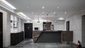 A modern kitchen with a central island, a coffee machine, and pendant lighting. - ZZZ HOTEL (Jiaoxi)