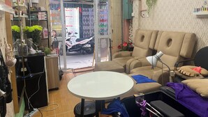 Una stanza con un divano, un tavolino e una motocicletta davanti alla porta.