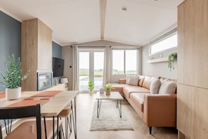 Ein modernes Wohnzimmer mit Sofa, Couchtisch und Essbereich.