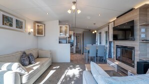 Una sala moderna con sofá, chimenea y comedor.