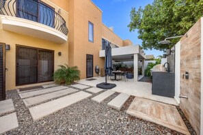 A courtyard with a patio, seating area, and a small pool.