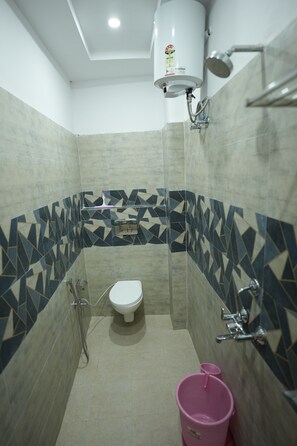 Un bagno piccolo con il water, una doccia e uno scaldabagno a parete.