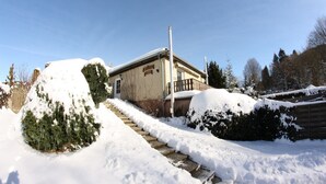 A snow-covered building with a staircase leading up to the entrance. - Wohnung am Diemelsee bei WillingenWinterberg (Diemelsee)