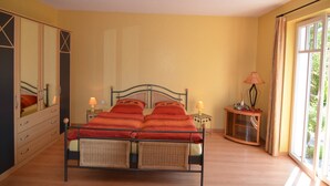 A bedroom with a bed, bedside tables, a mirror, and a window. - Stilvolle Wohnung in Madfeld mit eigener Terrasse (Brilon-Madfeld)