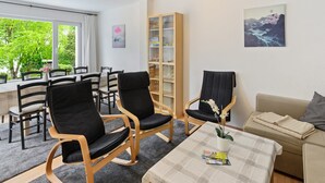 A room with a dining area, a sofa, and a bookshelf. - Ferienhaus Bergfreiheit (Winterberg)