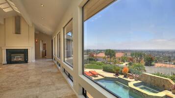 Enjoy a serene view of the pool and garden from the comfort of your room, with a fireplace and high ceiling.