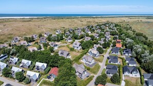 Vista aérea de una zona residencial con casas, carreteras y una costa.