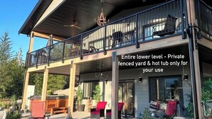 Un bâtiment à deux étages, avec un rez-de-chaussée partiellement abrité et une cour privée clôturée, comprenant un jacuzzi.