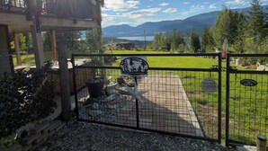 Une cabane en bois dotée d’un balcon offrant une vue imprenable sur un paysage magnifique, avec des montagnes et un lac.