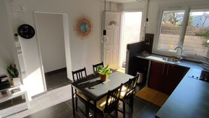 A compact kitchen with a dining area, a sink, and a window providing natural light. - T2 45m2 quiet and close to all amenities (Lattes)