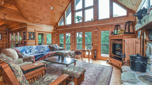A spacious cabin with a large living area featuring a sofa set, a coffee table, and a fireplace. - Bair Necessities relaxing Cabin (Old Fort)