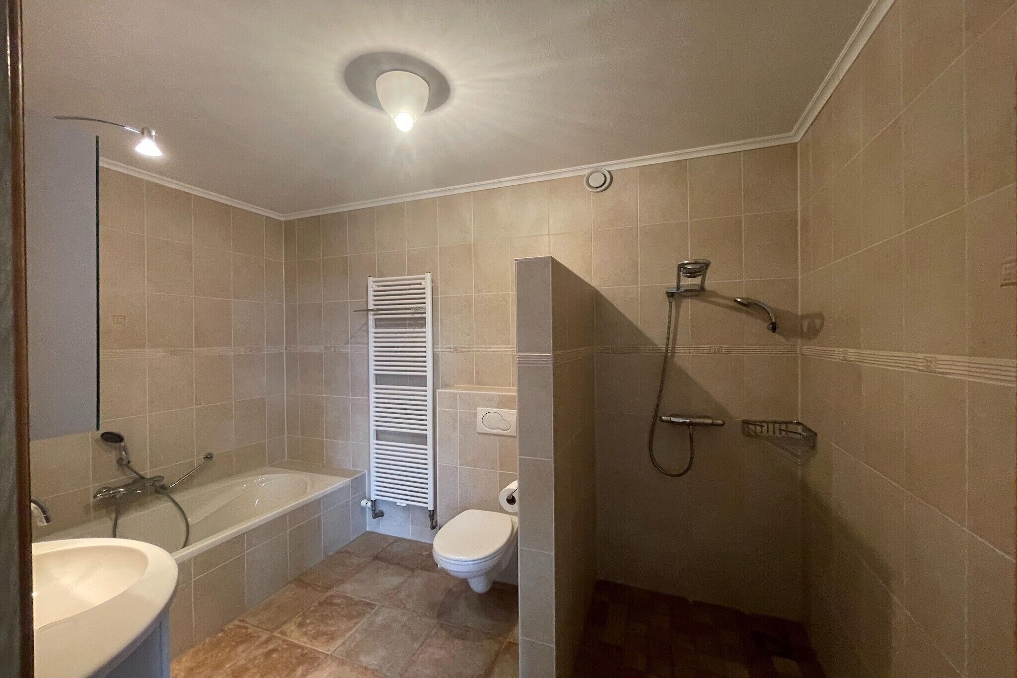 Een badkamer met bad, toilet en douche.