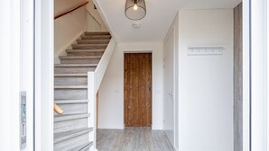 A staircase with wooden steps leading to a wooden door. - Holiday home near forest with wellness garden (Den Burg)