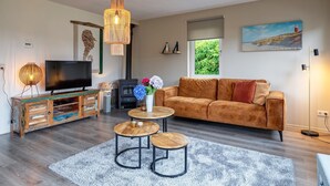 A living room with a TV, wooden coffee table, sofa, and decorative items.