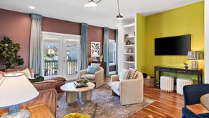 A modern living room with a sofa set, a coffee table, a TV, and a bookshelf.