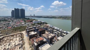 A high-rise building with multiple floors and a view of a river and surrounding cityscape. - River view pool gym train market wifi (Nonthaburi)