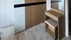 A bedroom with a wardrobe, a bedside table, and a mirror. - River view pool gym train market wifi (Nonthaburi)