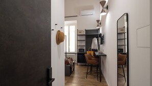 A modern kitchen with a dining area, a large mirror, and a wardrobe. - Style & Stone Guest House (Rome)