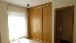 A bedroom with a bed, a wardrobe, and a door. - Villa Garden, Pool & sea (El Campello)