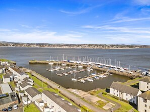 Un puerto deportivo con barcos amarrados, rodeado de edificios residenciales.