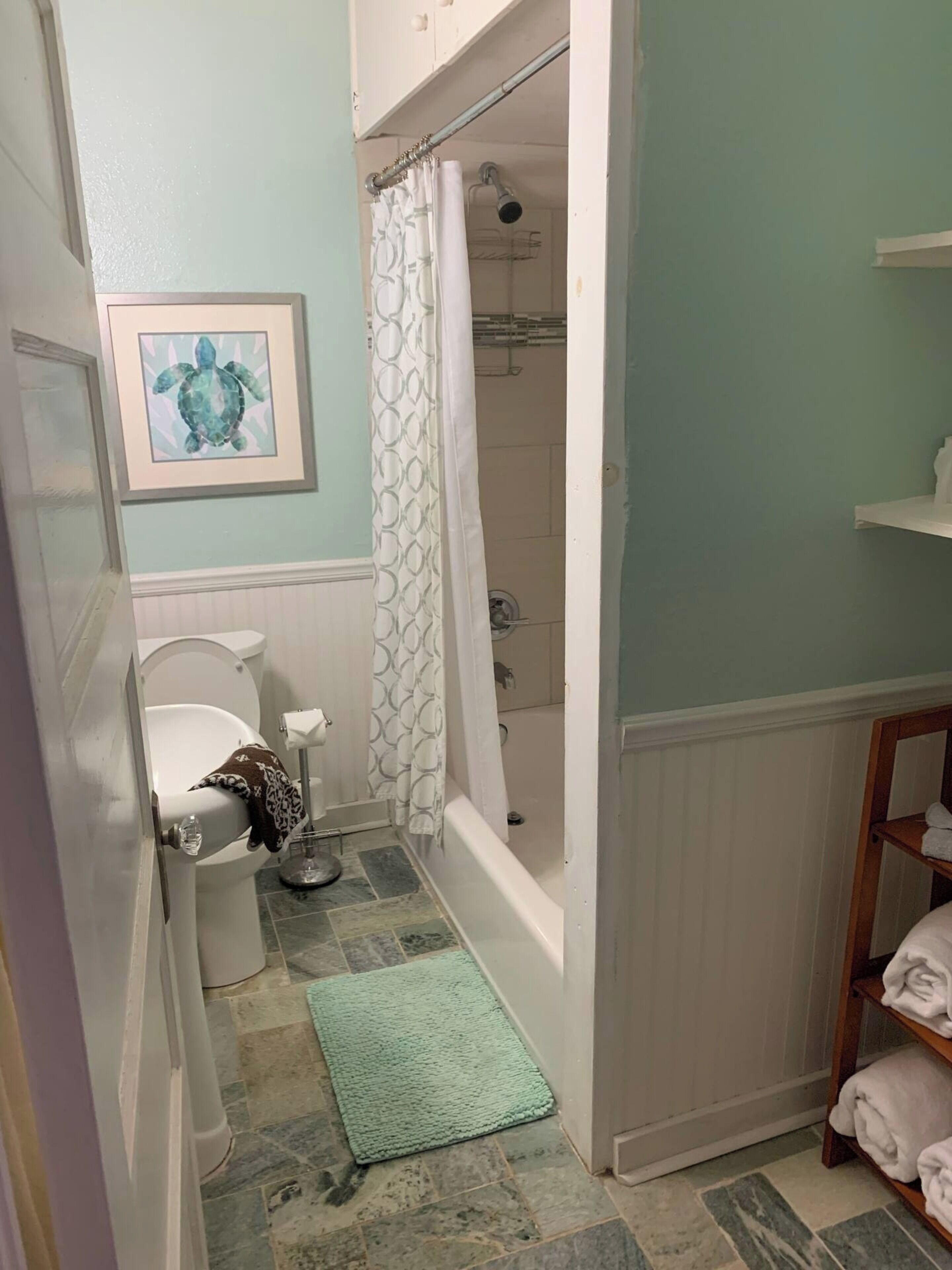 Ein Badezimmer mit Toilette, Dusche und Handtuchhalter.