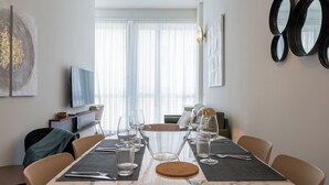 A dining area with a table set for six, a television, and artwork on the walls.