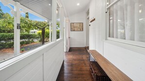 A covered porch with a wooden bench, white walls, and a view of greenery outside. - Bisham Cottage
Fully renovated two bedroom Cottage with a brand new out door Spa (Katoomba)