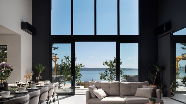 A modern living room with a large window overlooking a body of water. - Villa Soho - Your Luxury Dream Retreat in Croatia (Starigrad)