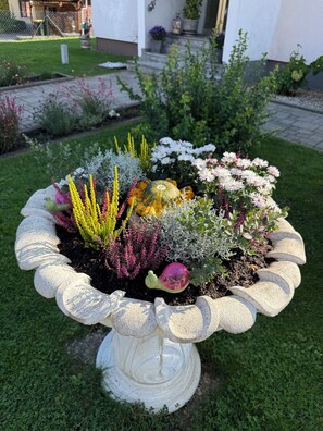 A garden planter with a variety of plants and a decorative pumpkin.