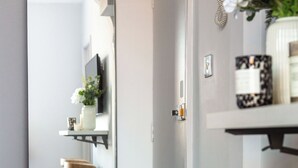 Un bagno moderno con uno specchio grande, uno sgabello di legno e uno scaffale con articoli da toilette.