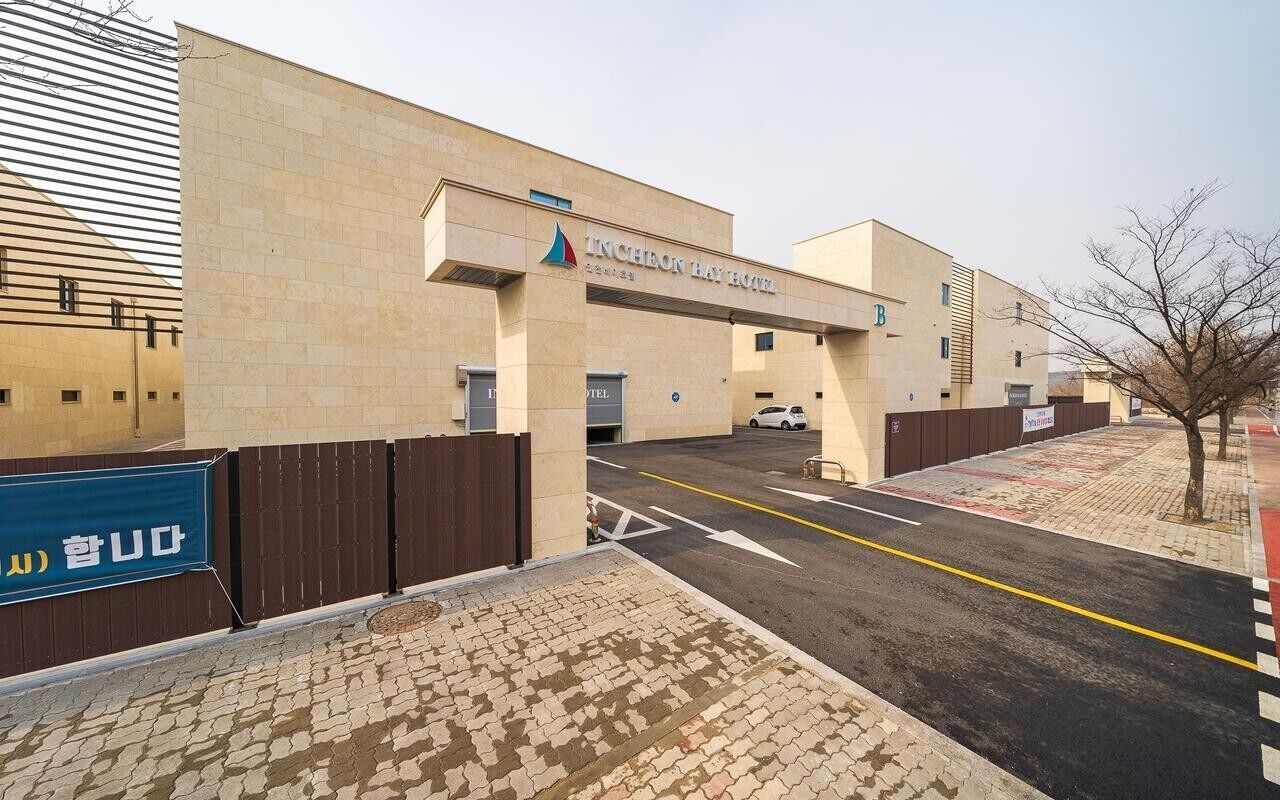 L’extérieur de l’hôtel Incheon Bay présente une entrée bien dégagée, un chemin piétonnier aménagé et un espace de stationnement.