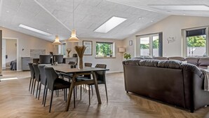 A spacious living area with a dining table, chairs, a sofa, and a kitchen in the background. - "Alvira" - 30km from the sea by Interhome (Toftlund)