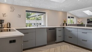 A modern kitchen with grey cabinetry, a large window, and a herringbone wood floor. - "Alvira" - 30km from the sea by Interhome (Toftlund)