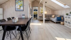 A modern interior with a dining area, a sofa, and a view of the outdoors. - "Aika" - 450m from the sea by Interhome (Hejls)