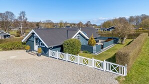 A blue house with a grey roof, surrounded by a white fence, and a gravel driveway. - "Aika" - 450m from the sea by Interhome (Hejls)