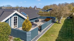 A blue house with a sloped roof, a patio with outdoor furniture, and a small garden area. - "Aika" - 450m from the sea by Interhome (Hejls)