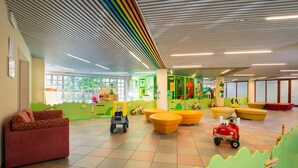 A children's play area with colorful furniture, a play structure, and a toy train.