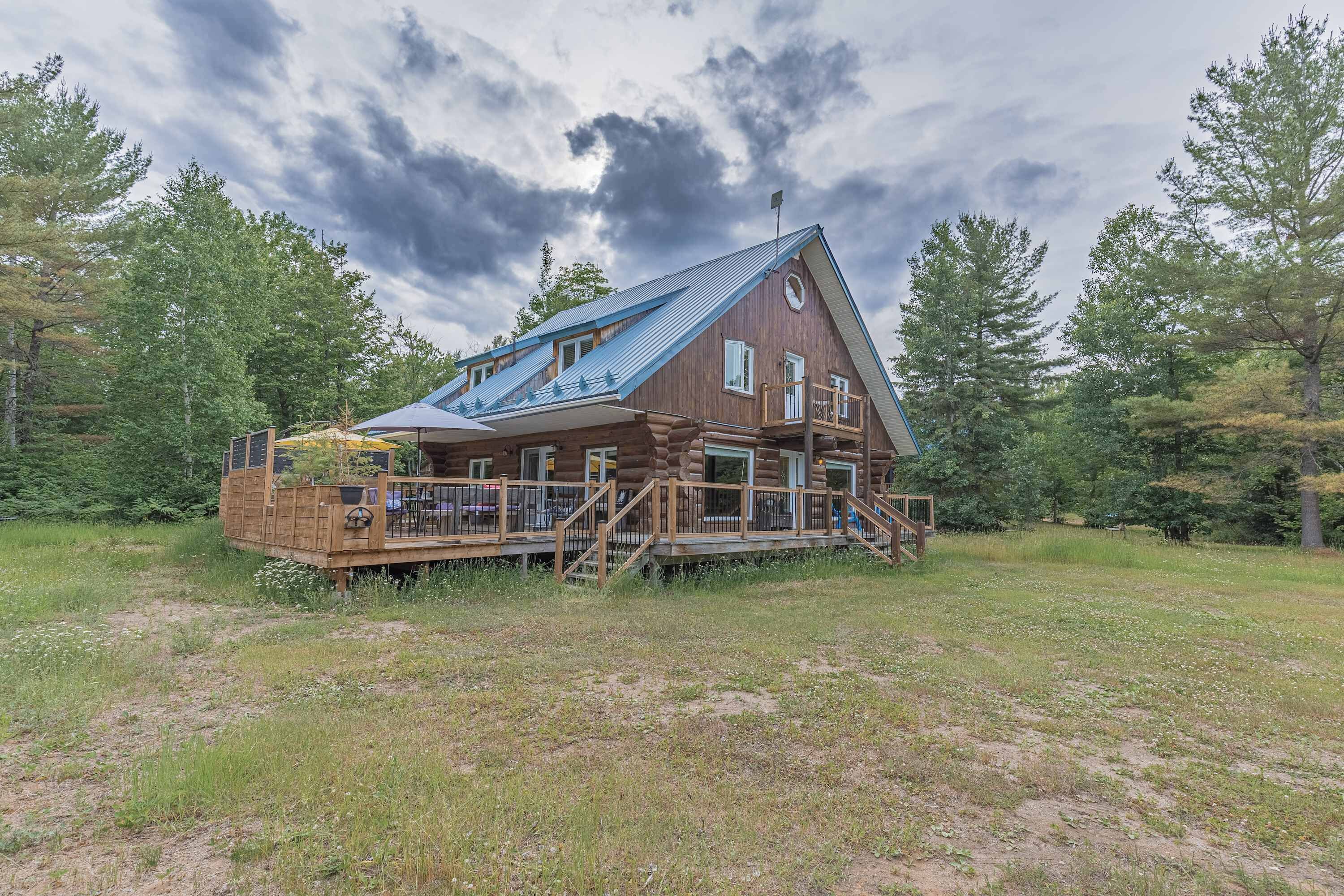 Expansive aerial shot highlighting the cabin’s peaceful woodland setting