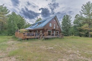 A log cabin with a deck and a covered outdoor area.