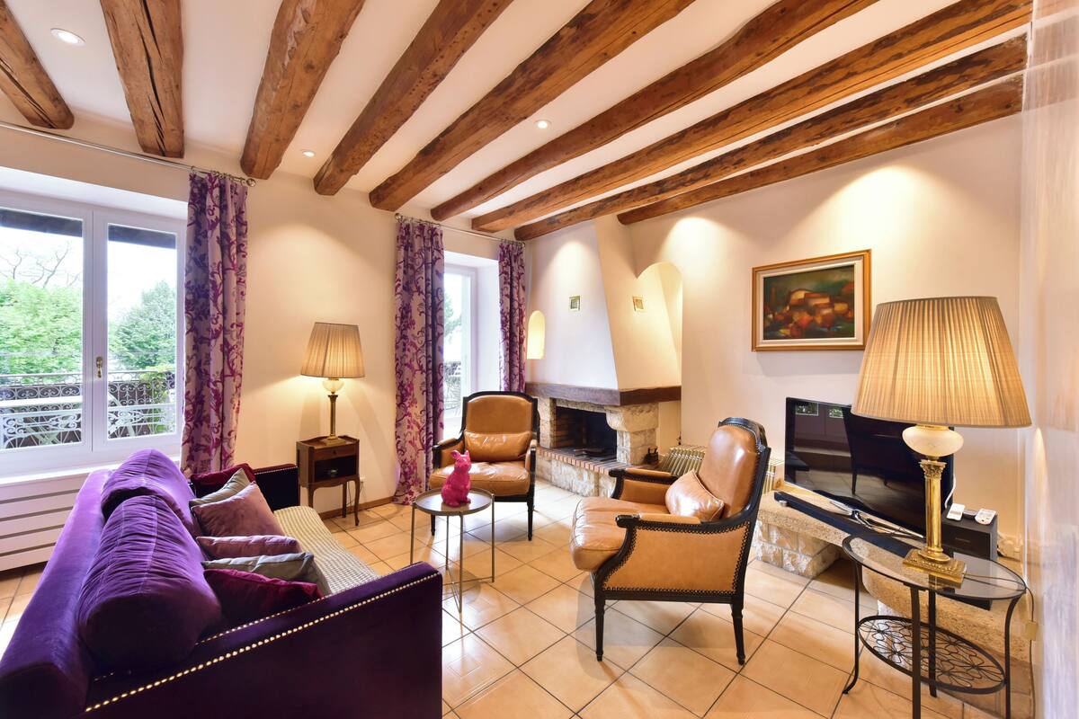 Una sala acogedora con sofá, sillones, chimenea y televisor.