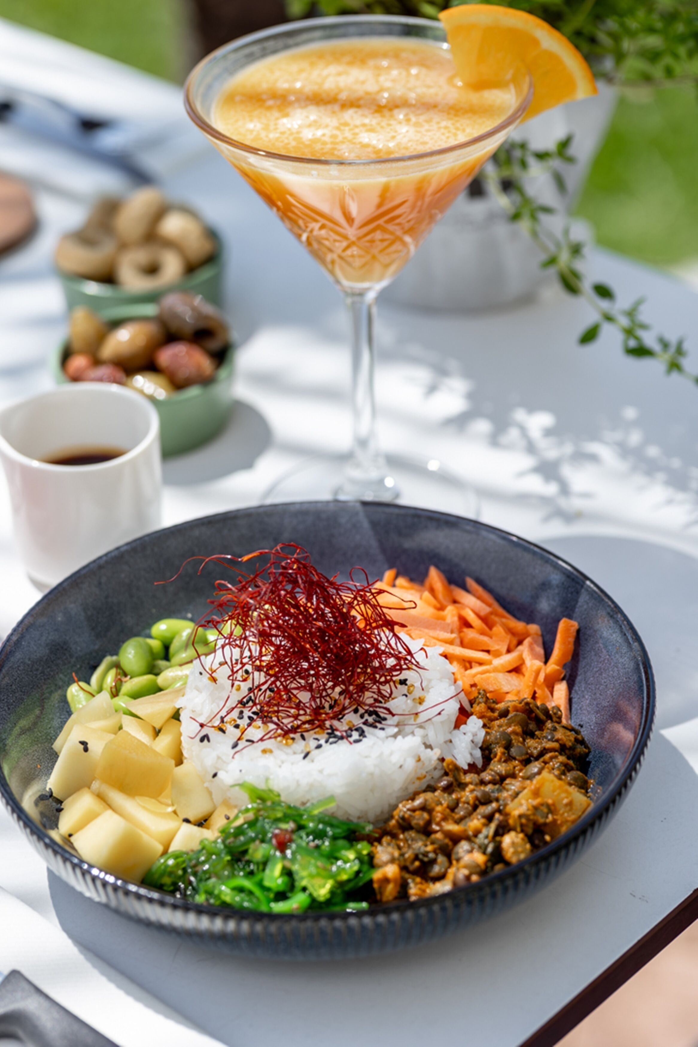 Un repas composé de riz, de légumes et d’une boisson, servi sur une table.