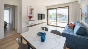 Una sala de estar moderna con un sofá, una mesa de comedor y un televisor.