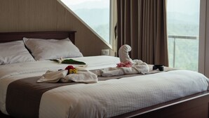 Une chambre d’hôtel avec un lit, une fenêtre avec des rideaux et une vue sur les montagnes.