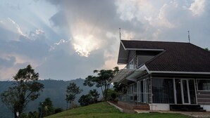 Une maison moderne dotée d’un toit en pente, de grandes fenêtres et d’une extension à toit plat.