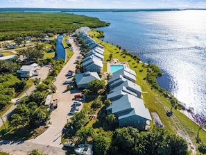 A resort with multiple buildings, a swimming pool, and a marina with boats.