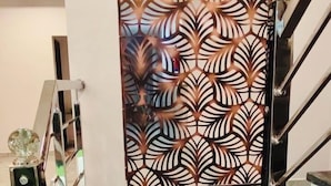 En hotellentrél med en dekorativ dörr, en inramad religiös staty eller bild, och en trappa.