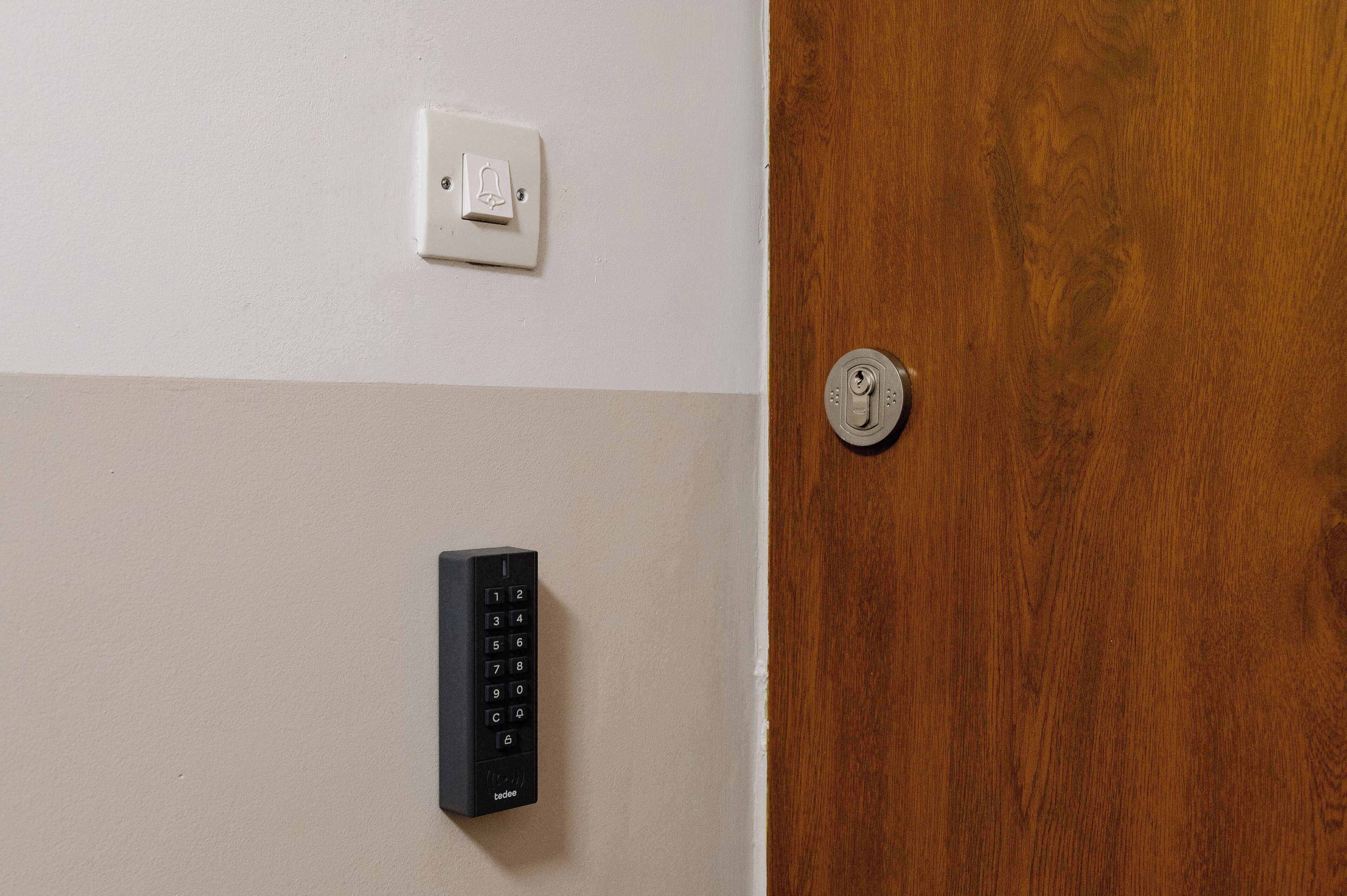 A door with a keyhole and a wall-mounted keypad.