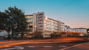 Un immeuble à plusieurs étages doté d’une architecture moderne, avec un escalier central et de nombreuses fenêtres.
