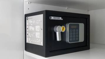 A black electronic device with a keypad and a small cylindrical object, possibly a sensor or remote, next to it.
