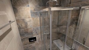 Een moderne badkamer met een douchecabine van glas, een toilet en een wastafel.